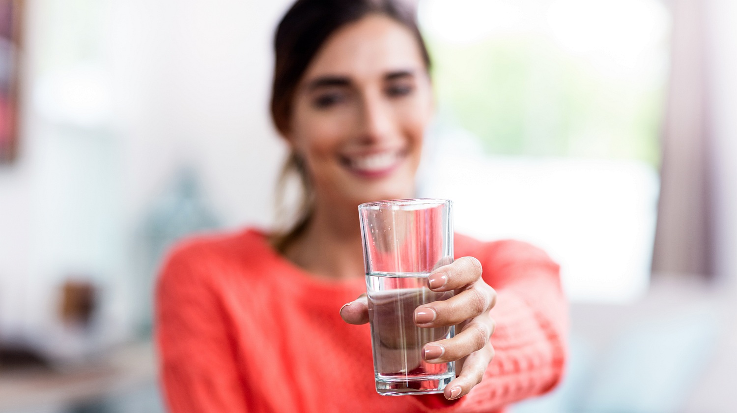 Feature | Woman showing a glass of water | Introducing Your Body To Alkaline Water | alkaline water benefits