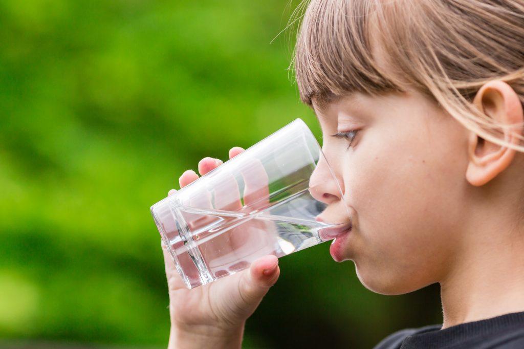 Child drinking glass of fresh water