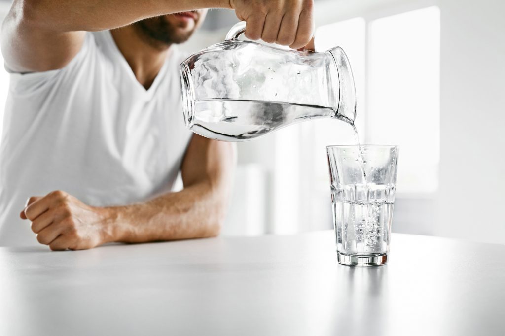 Drink Water. Close Up Man Pouring Water Into Glass. Hydration