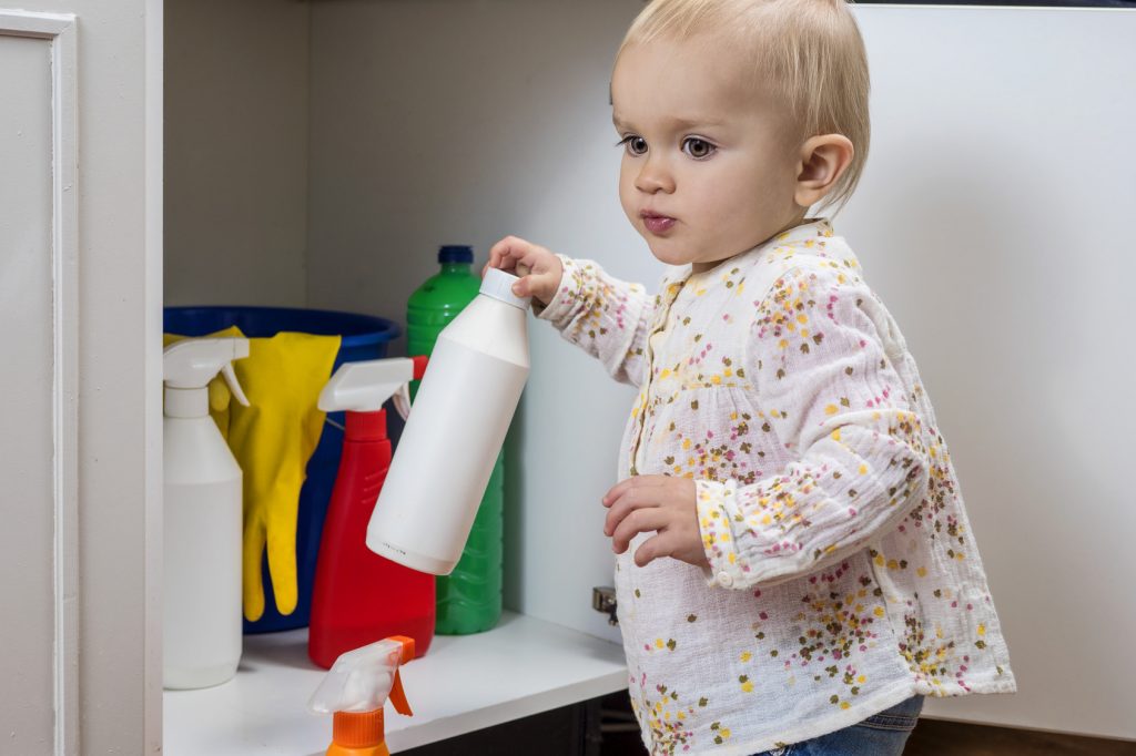 Little girl playing with household cleaners