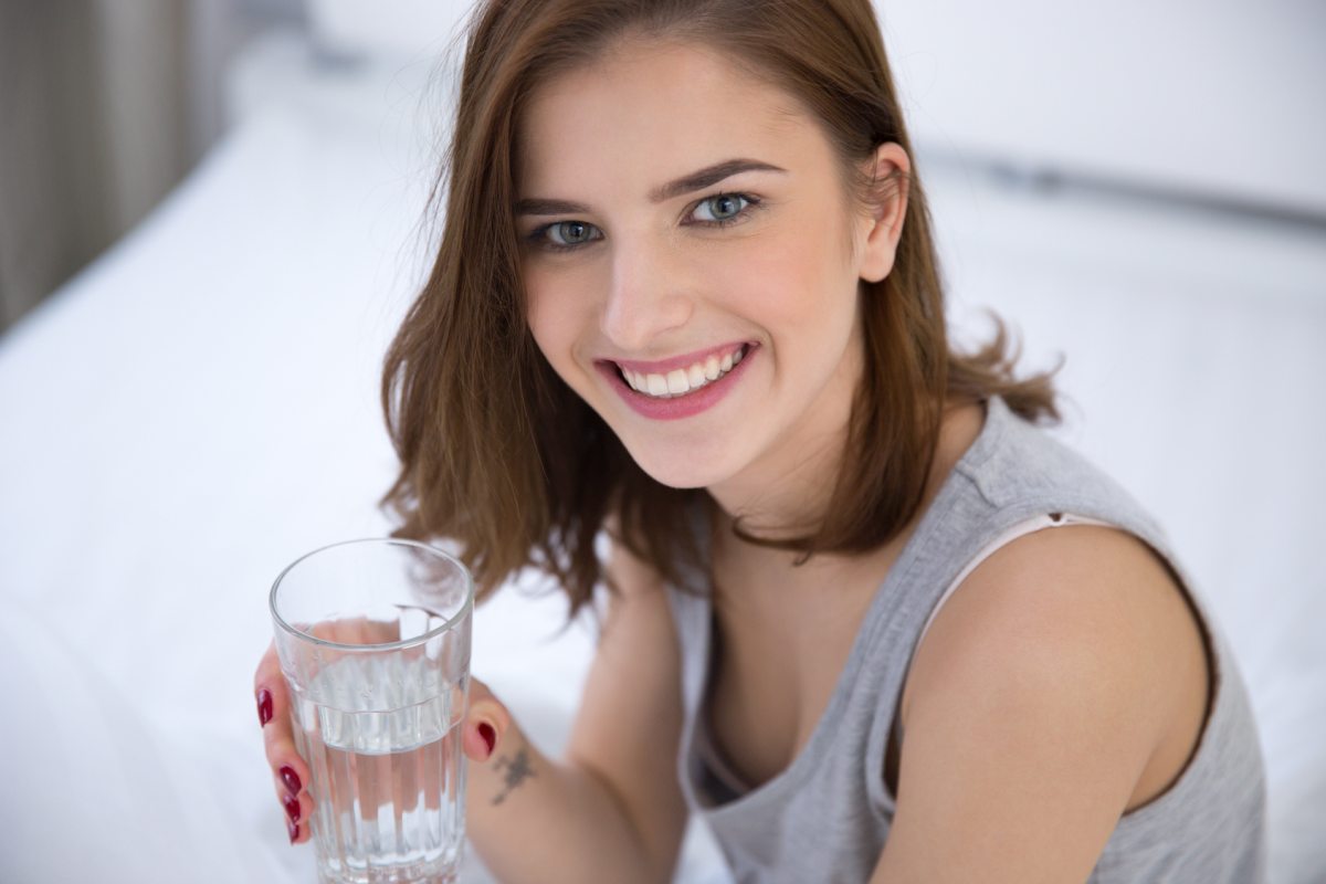 Happy woman drinking alkaline water | Alkaline Water And Urine