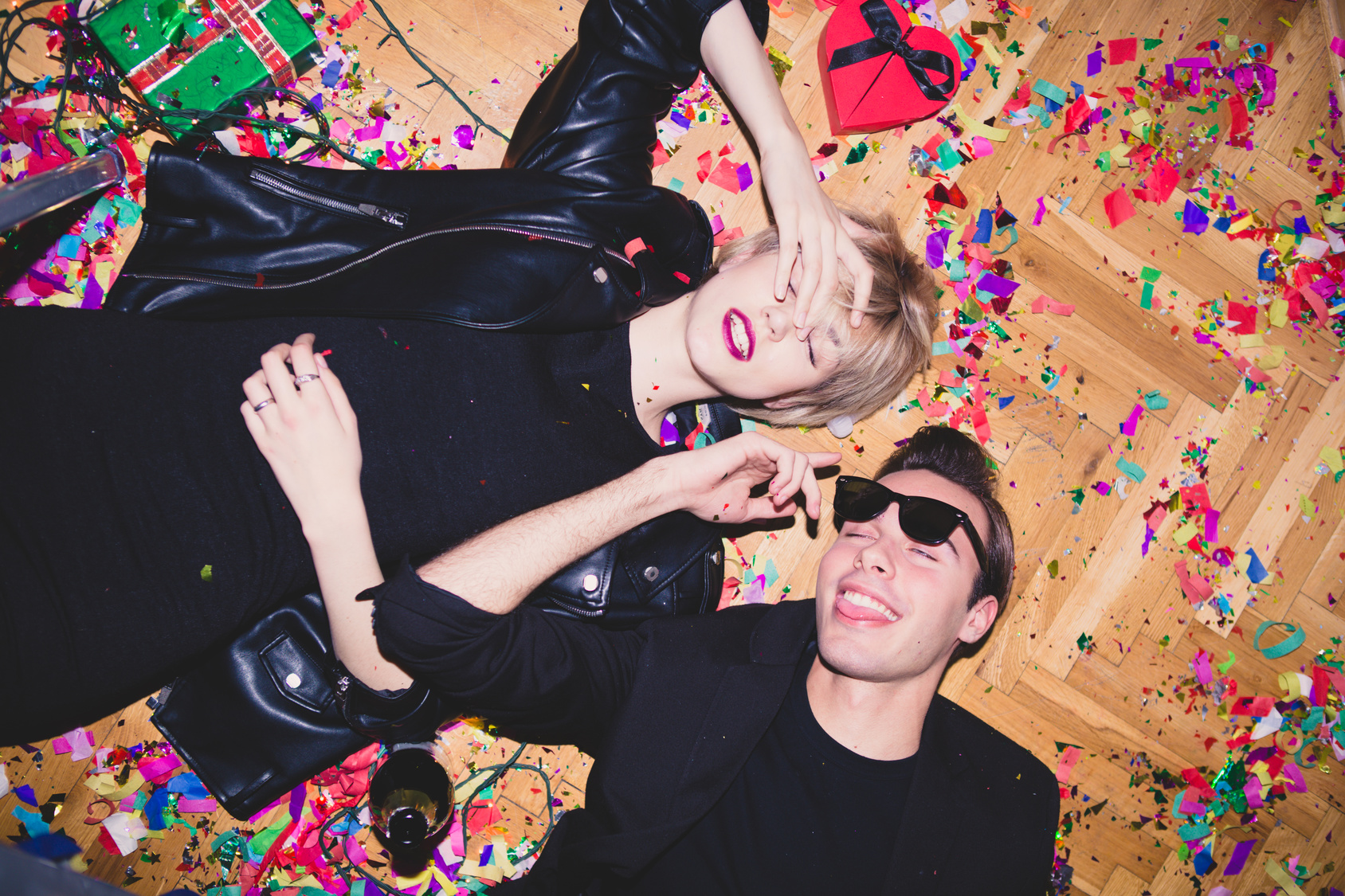 New Year's Party. Girl and boy laying on the floor full of confetti