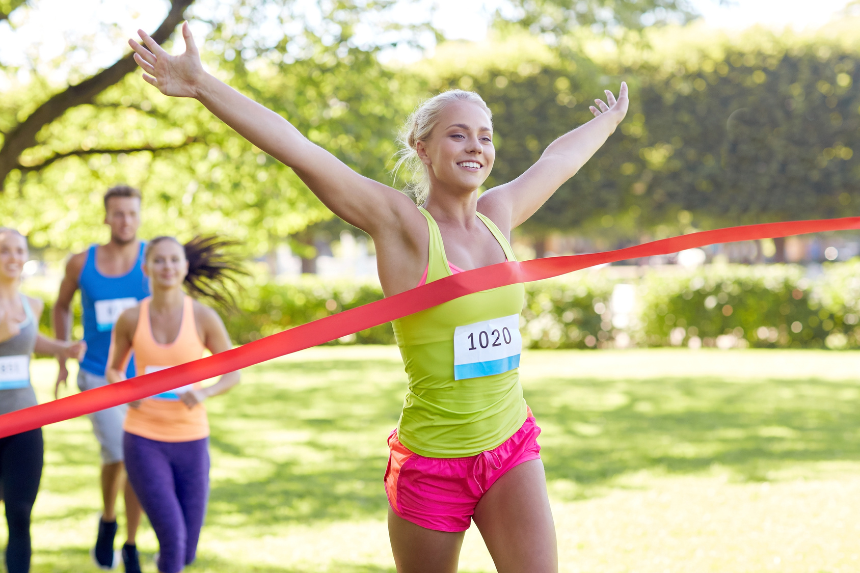 happy young female runner winning on race finish