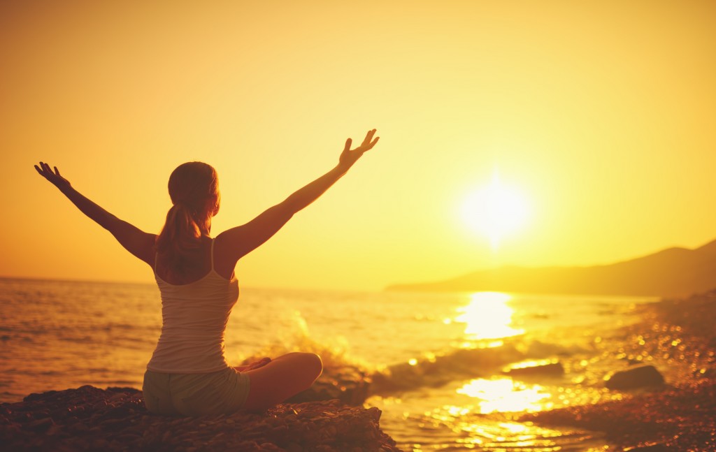 yoga at sunset on beach. woman doing yoga