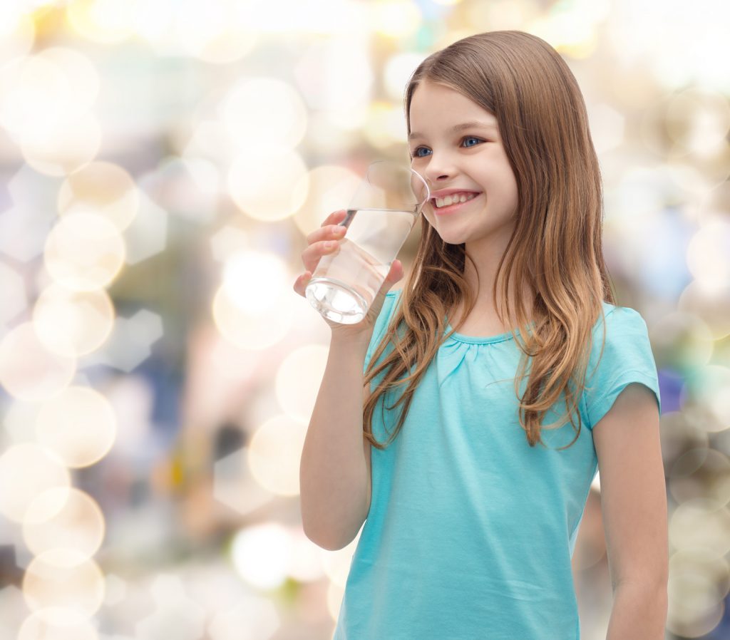 smiling little girl with glass of water
