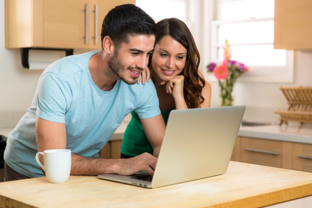 Couple husband and wife writing typing on new modern laptop computer device blogging sharing chatting