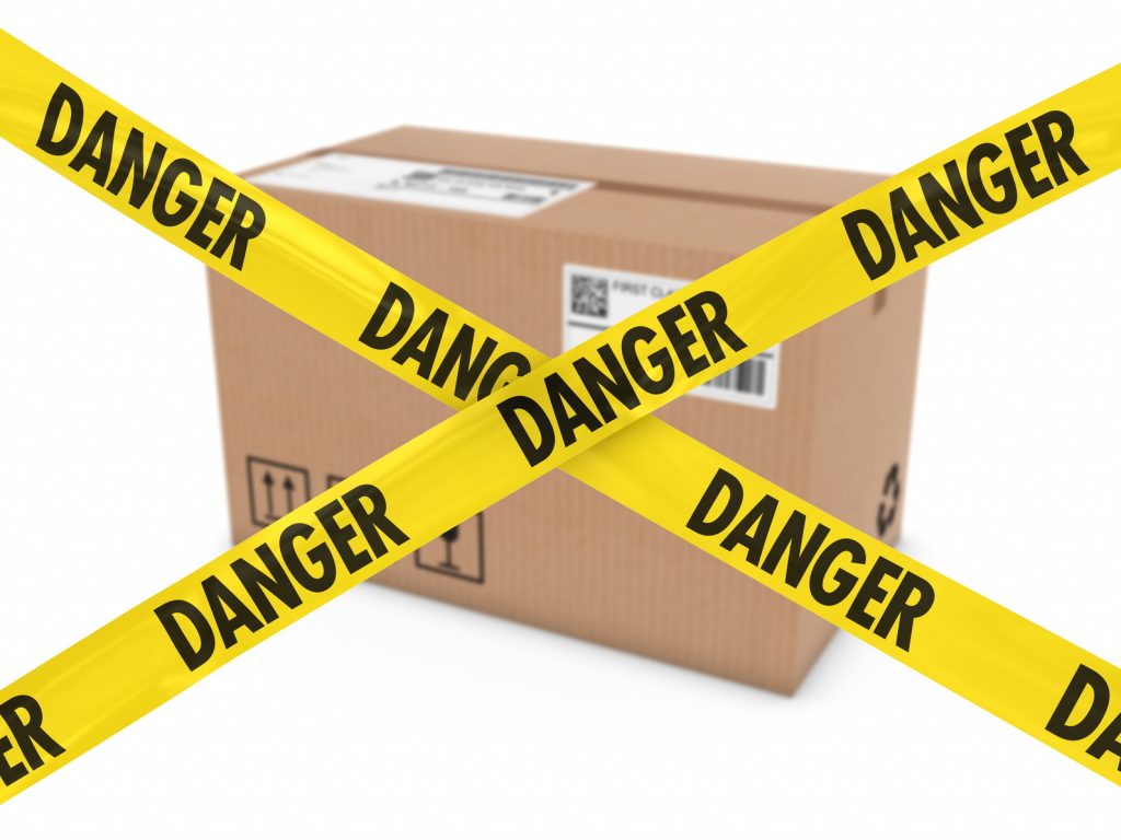 Suspicious Parcel Concept - Cardboard Box behind Danger Tape Cross