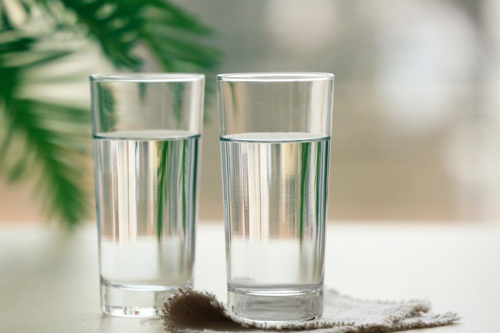 Two glasses of pure water on blurred background