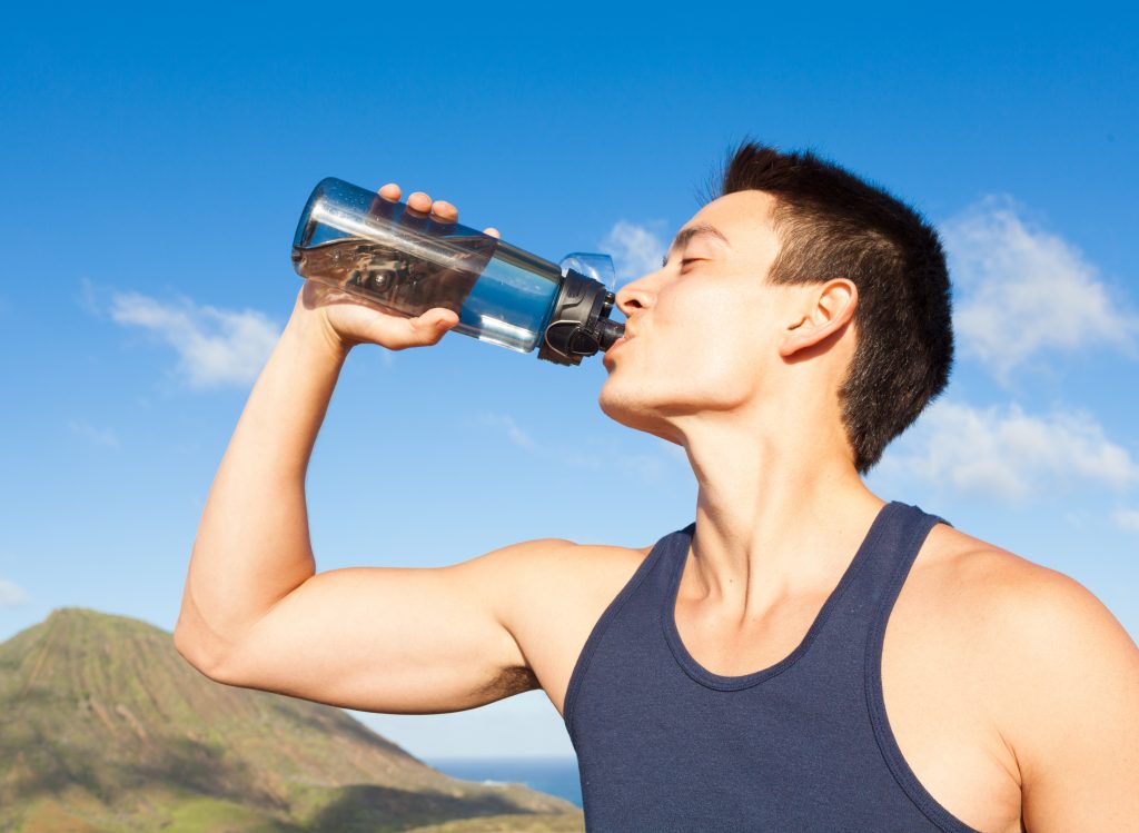 Young fit male drinking water.