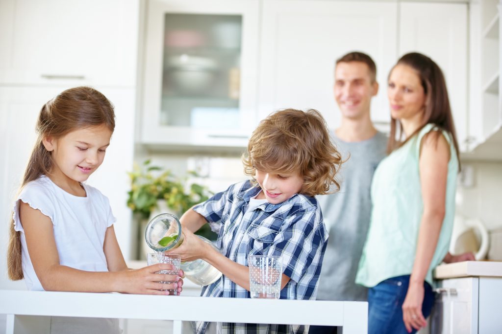 Zwei Kinder trinken Wasser mit frischen Limetten