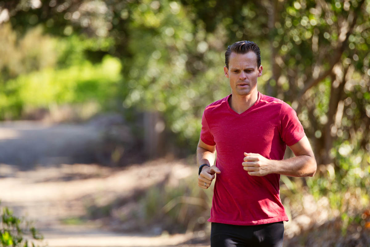 Man running on path surrounded with trees | What Is Alkaline Water? | What You Need To Know