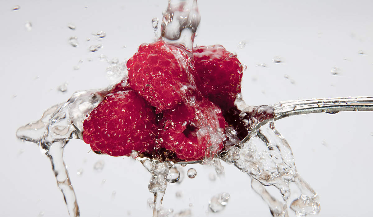 Raspberries being washed on spoon | Fruits and Veggies That Can Keep You Hydrated