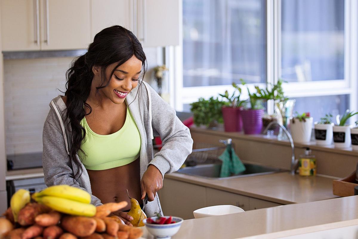 Woman slicing pear | High Alkaline Foods To Add To Your Diet