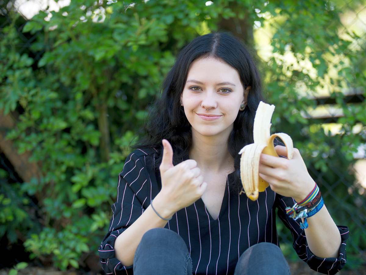 Beautiful woman eating banana | High Alkaline Foods To Add To Your Diet