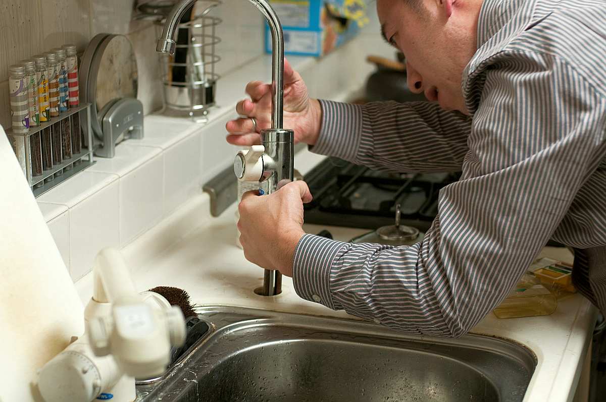 Man fixing faucet | Reasons Why Acidic Water Is Bad For You