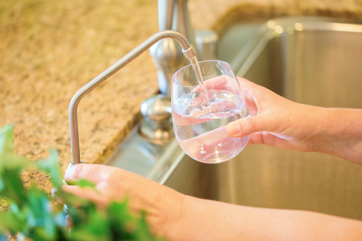 woman pouring fresh water | Does Reverse Osmosis Remove Healthy Minerals From Drinking Water? | healthy minerals from water