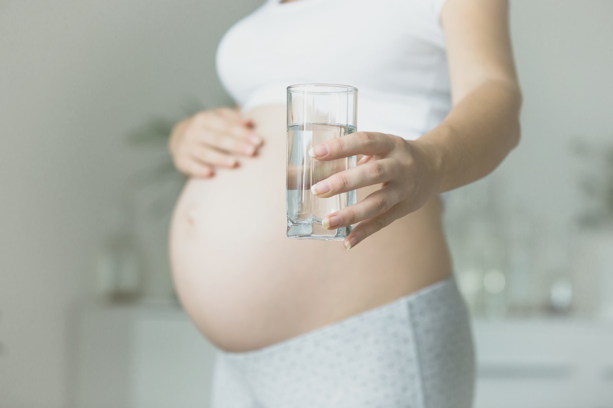 pregnant woman holding glass of water | How Contaminated Water Can Cause Birth Defects (And How to Avoid It) | common birth defects