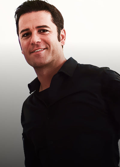Actor Yannick Bisson wearing a black shirt against a gradient background